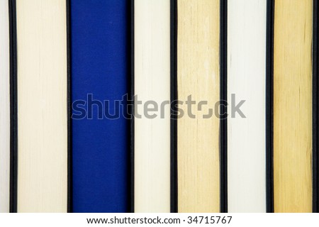 Group of books in a row and one book standing out from others with spine showing.