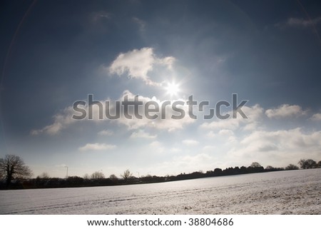 The Sun shining low over a snow covered field on a Beautiful winters day
