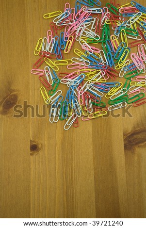 Elevated View of Coloured Paper Clips on a wooden table