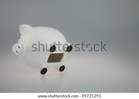 White Piggy bank on its side with Coin slot open showing piggy bank empty
