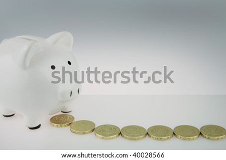 White Piggy bank With British One Pound Coins  in front of money box,