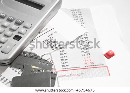 bank statement and credit card cut into little pieces and a broken Calculator with the Minus button pulled out.