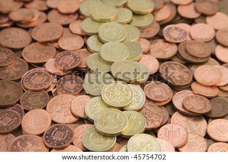 a pile of Bank of england one pence and two pence Coins with one pound coins in the centre of image