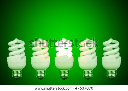 Low energy lightbulb switched on in the centre of switched off light bulbs