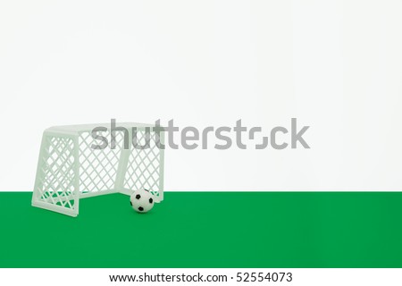 small table top football goal posts and small football on the edge of a green table