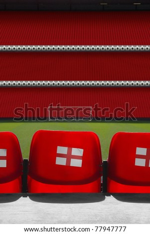 view behind empty seats at a empty football stadium with the england St George\'s flag on the back of the seats
