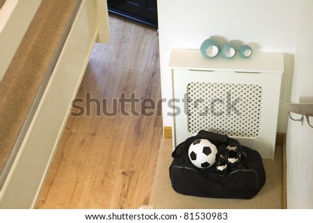 football kit bag,ball and football boots ready to take at the bottom of the home stairs