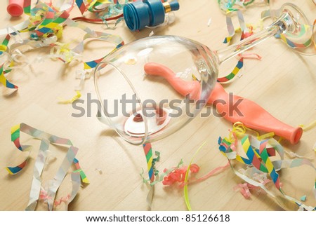 Over head shot of a wooden floor after a party celebration with empty wine glass and party decorations,