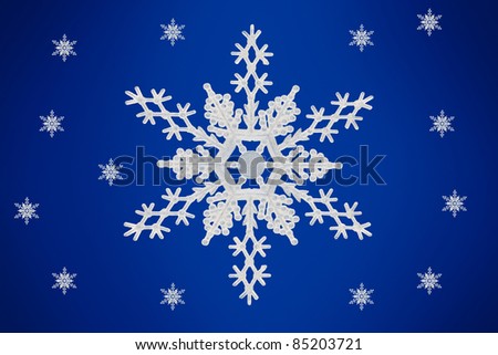 Close up of a Snow Flake with smaller snow flakes in the background