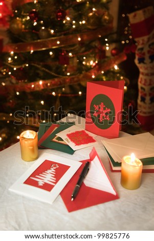 selection of home made Christmas cards on a table with envelopes, candles and a ink fountain pen