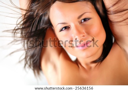 Portrait of the beautiful naked girl with the hands lifted for a head. Hair develop on a wind.