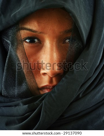Asian woman peeking out from behind veil