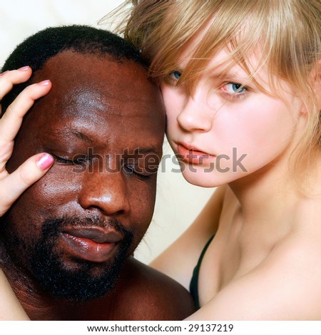 Young beautiful blond woman embraces a head of the black man, isolated on a white background, please see other photos of this series