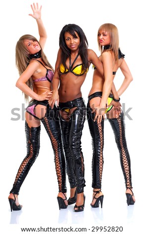 stock photo Three emotional young beautiful girls in trousers from latex 