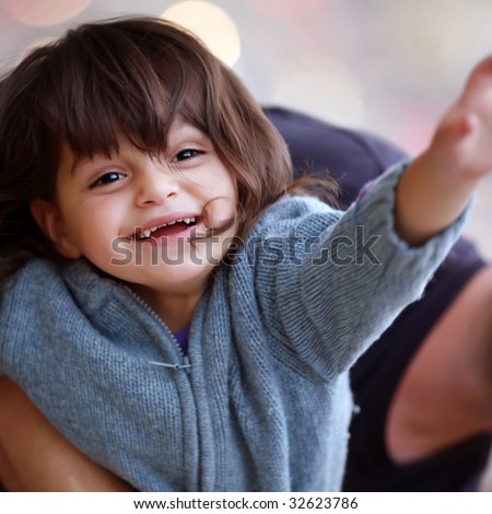 Child with happiness in eyes, feeling kindness of the world up to tips of fingers and its iridescent paints.