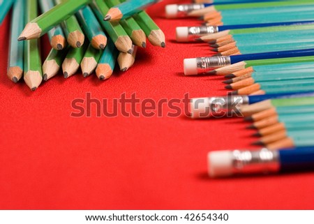 A lot of pencils on red backgrounds with shallow depth of field, focus on line eraser of pencils