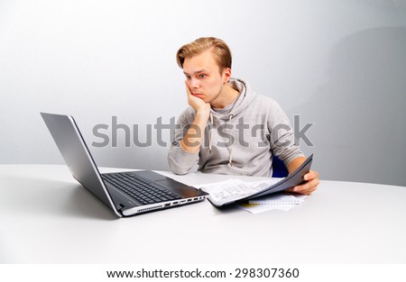 Office worker thinking. Blonde sitting at a table in front of a computer.