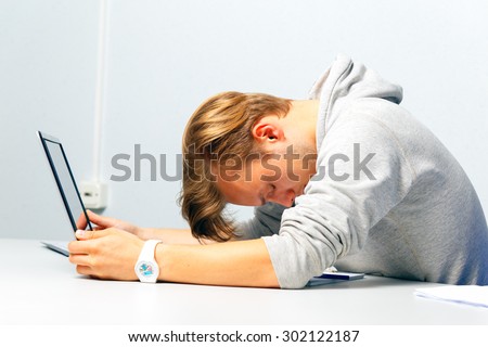 Office worker was tired. Stress at work. Blonde sitting at a table in front of a computer.