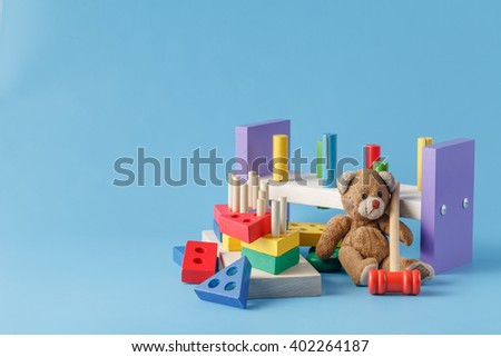Colorful wooden toy building blocks with toys on blue