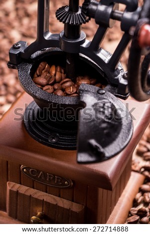 Retro coffee grinders with coffee grains  inside. Vertical shot. The background is blurred. Close-up.
