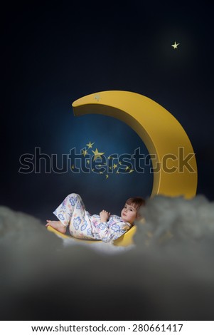 little girl lying on the moon in the night sky