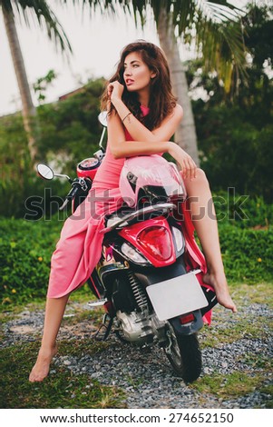 young stylish sexy beautiful woman in pink dress on scooter motorbike, sensual, tropical vacation, island