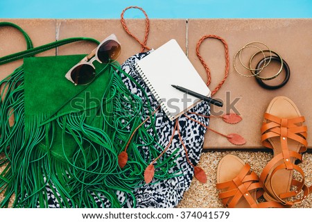 woman\'s accessories composed on floor, pool, still life, view from above, summer fashion trend, vintage boho style, vacation, notebook, sunglasses, sandals, dress, purse, pen, travel diary, bracelets