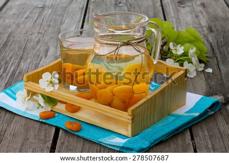 Sweet compote of dried apricots in a jar on a wooden background