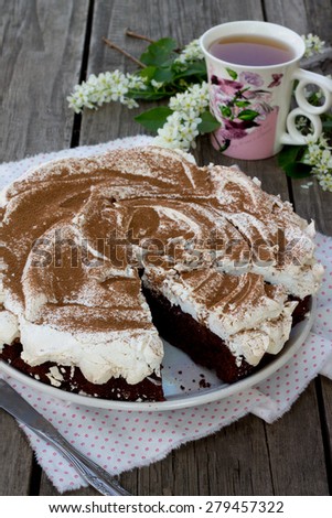 Cake chocolate-nut cake and meringue on wooden background
