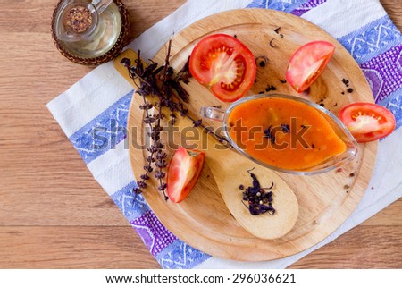 tomato sauce in a glass gravy boat on a wooden table