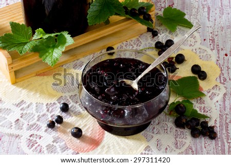 Black currant jam on a wooden background