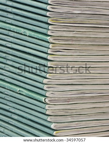 A pile of school exercise books with green covers