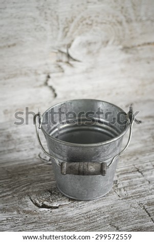 vintage bucket on a light wooden background