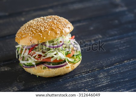 delicious veggie burger  on a dark wooden surface.  Healthy breakfast or snack