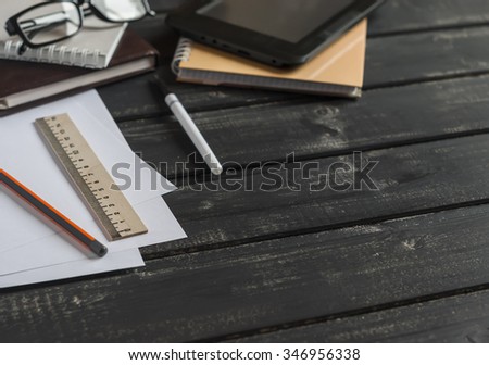 Office desk with business objects - open notebook, tablet computer, glasses, ruler, pencil, pen. Free space for text. Office workplace