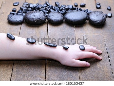 Volcanic hot stones for massage in woman body.