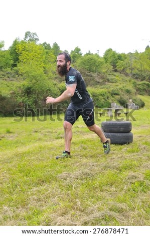 OVIEDO, SPAIN - MAY 9: Storm Race, an extreme obstacle course in May 9, 2015 in Oviedo, Spain. Runner dragging two car wheels.