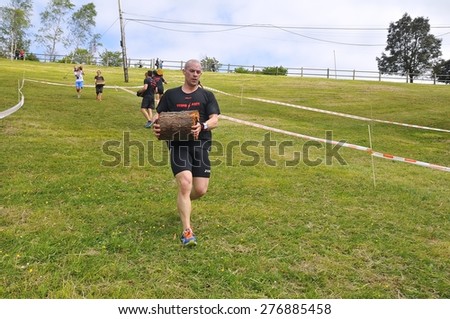 OVIEDO, SPAIN - MAY 9: Storm Race, an extreme obstacle course in May 9, 2015 in Oviedo, Spain. Runners carrying a trunk of a tree