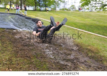 OVIEDO, SPAIN - MAY 9: Storm Race, an extreme obstacle course in May 9, 2015 in Oviedo, Spain. Runner sliding down a water slide