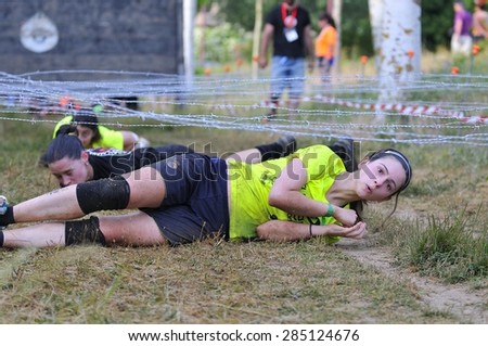 LEON, SPAIN - JUNE 6: Farinato Race, extreme obstacle race in June 6, 2015 in Leon, Spain. People jumping, crawling,passing under a barbed wires or climbing obstacles during extreme obstacle race.
