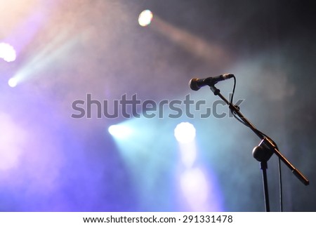 Microphone with spotlights with colored lights at a rock concert.