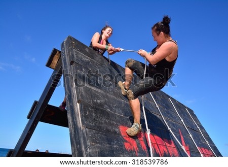 GIJON, SPAIN - SEPTEMBER 19: Storm Race, an extreme obstacle course in September 19, 2015 in Gijon, Spain. Participants in extreme obstacle course jumping a wooden wall.