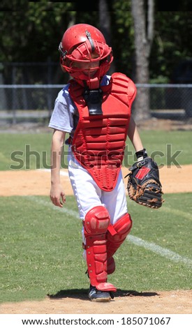 A Little League Catcher in all of his Protective Gear Walks to the Plate for the Big Game
