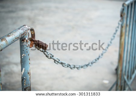 old rusty key lock locked with a chain
