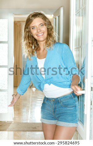 Young woman welcoming people at entrance door