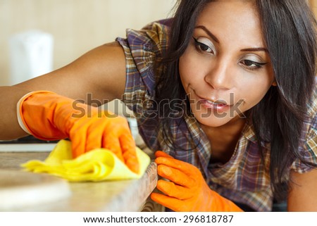 Beautiful housewife cleaning table