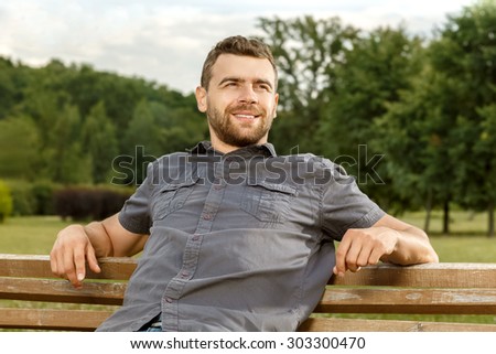 Man sits on the bench and relax in public park