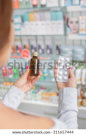 Beautiful girl can\'t decide what to buy in drugstore
