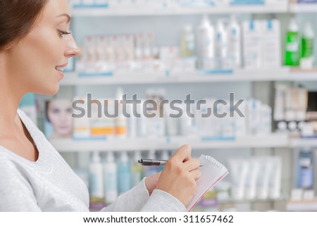 Customer making notes in drugstore