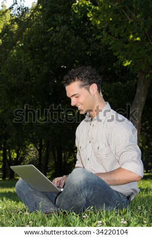happy businessman with laptop in the park